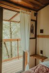 A sliding glass window frames your bed-view into the canopy